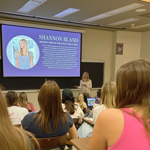 Students in a classroom listening to a student presentation