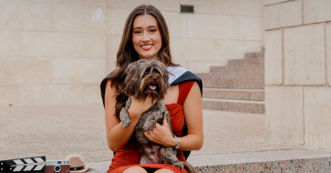 Madelyn Hayden pictured holding a dog sitting on stone steps