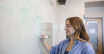 Student writing on whiteboard