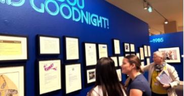 students looking at wall exhibit with docent