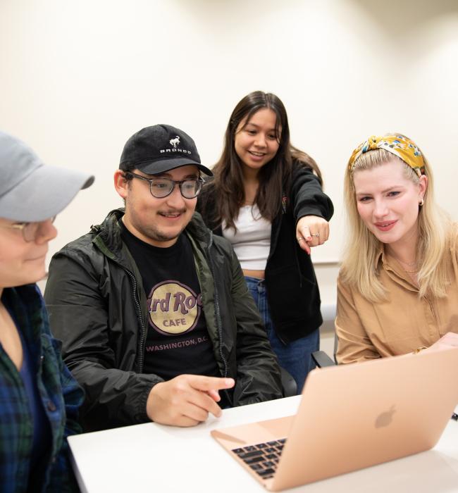 students pointing at a computer