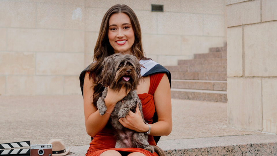 Madelyn Hayden pictured holding a dog sitting on stone steps