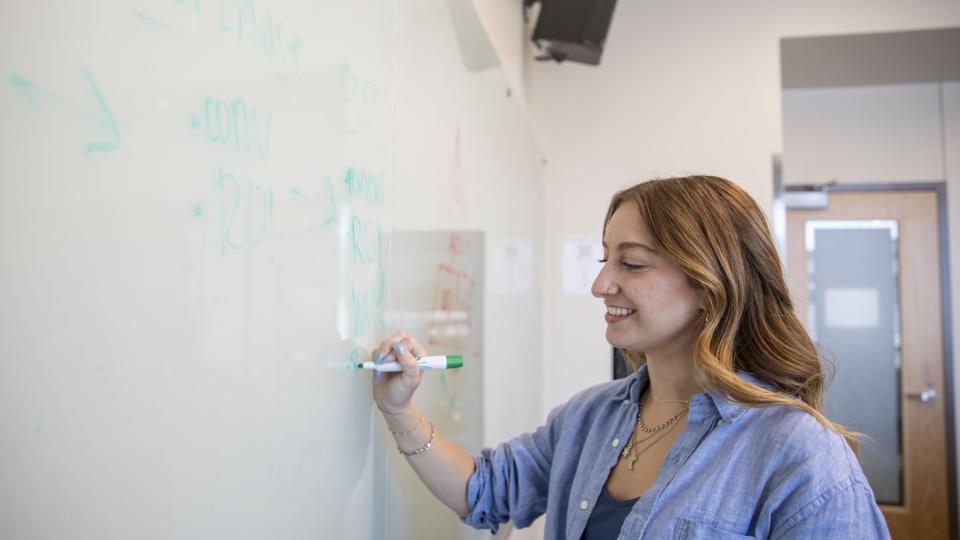 Student writing on whiteboard