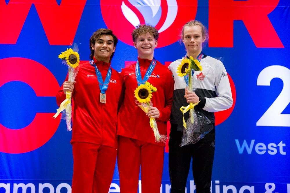 Tomas Minc on a Podium with 3 other men holding a sunflower