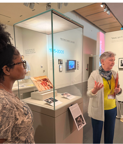 student listening to docent explain exhibit